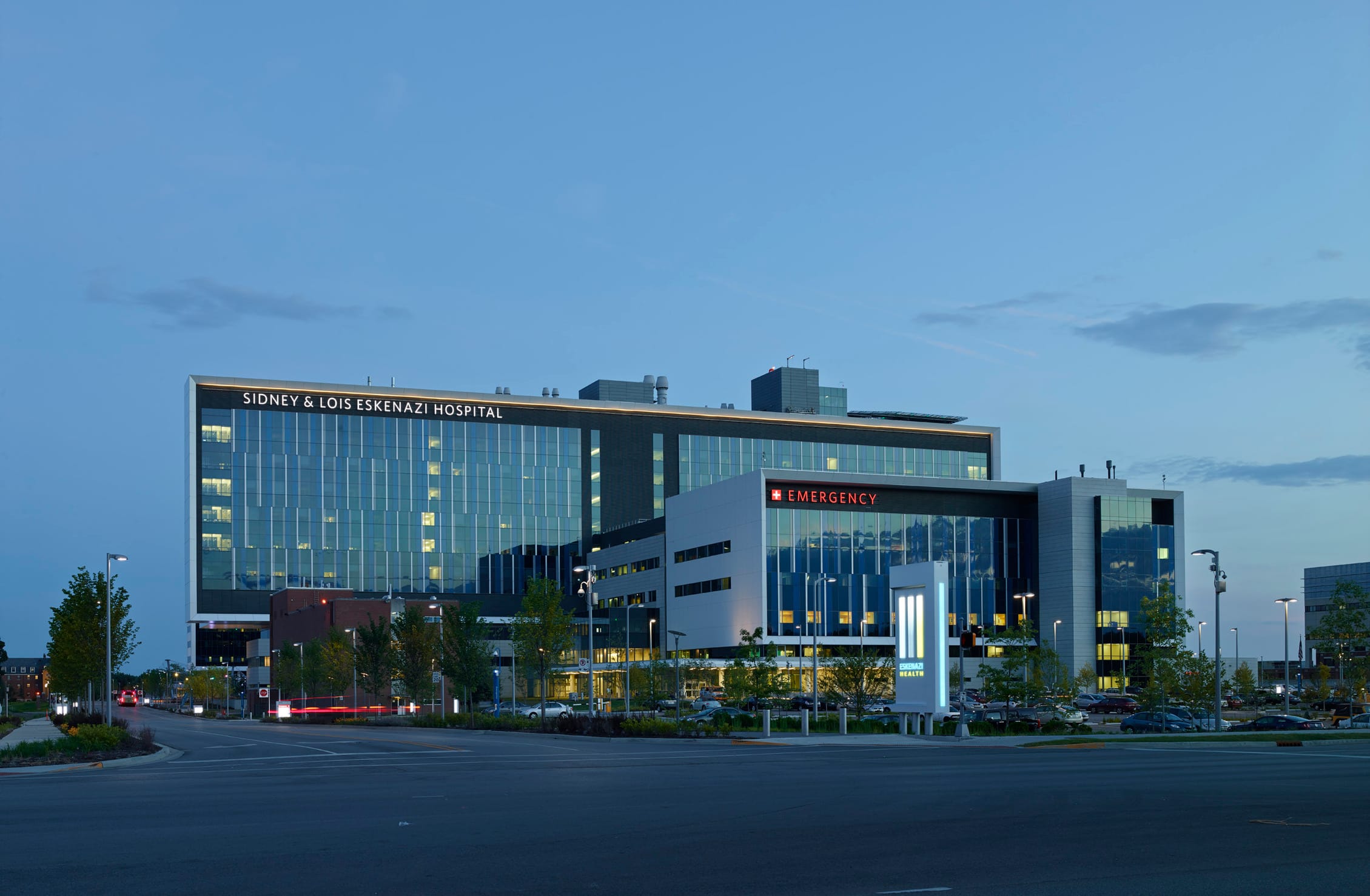 A modern hospital building with a sleek glass exterior at dusk. This image showcases BSA's expertise in architecture.