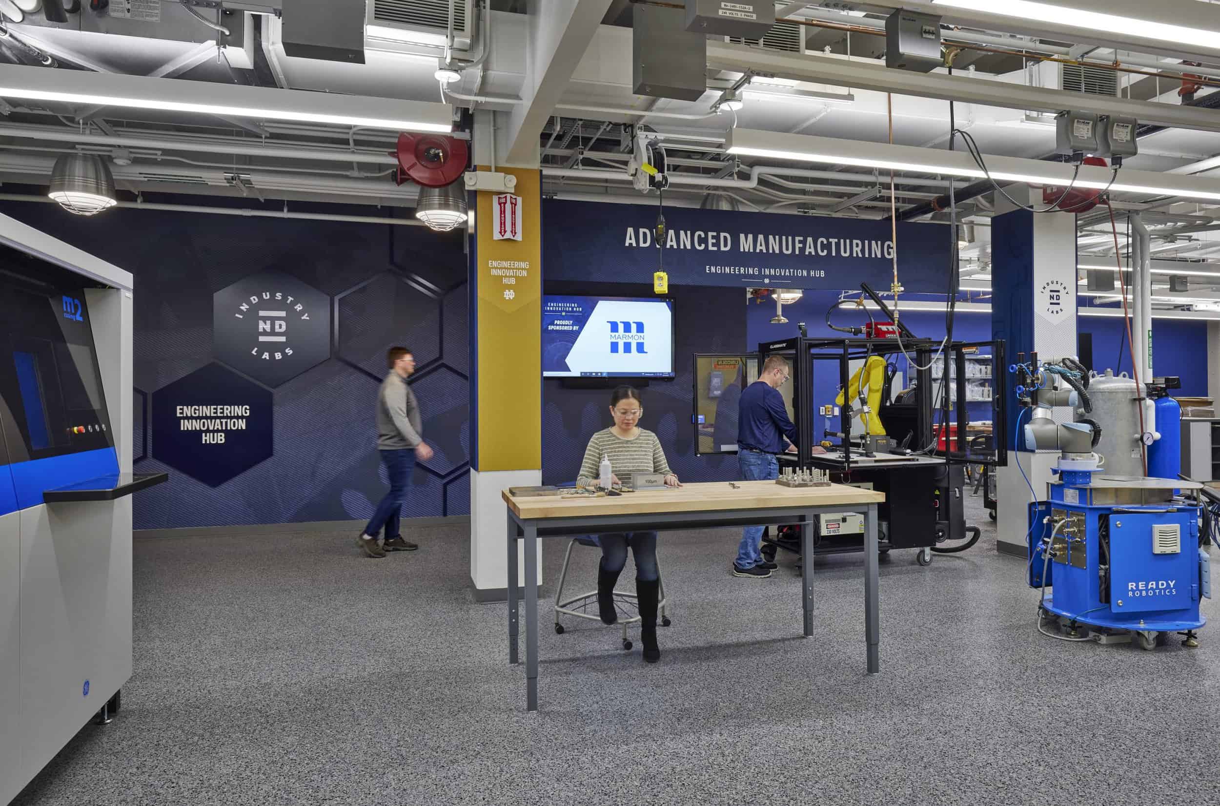 This image shows an advanced manufacturing and engineering innovation hub in Notre Dame. The space features deep blue walls with 