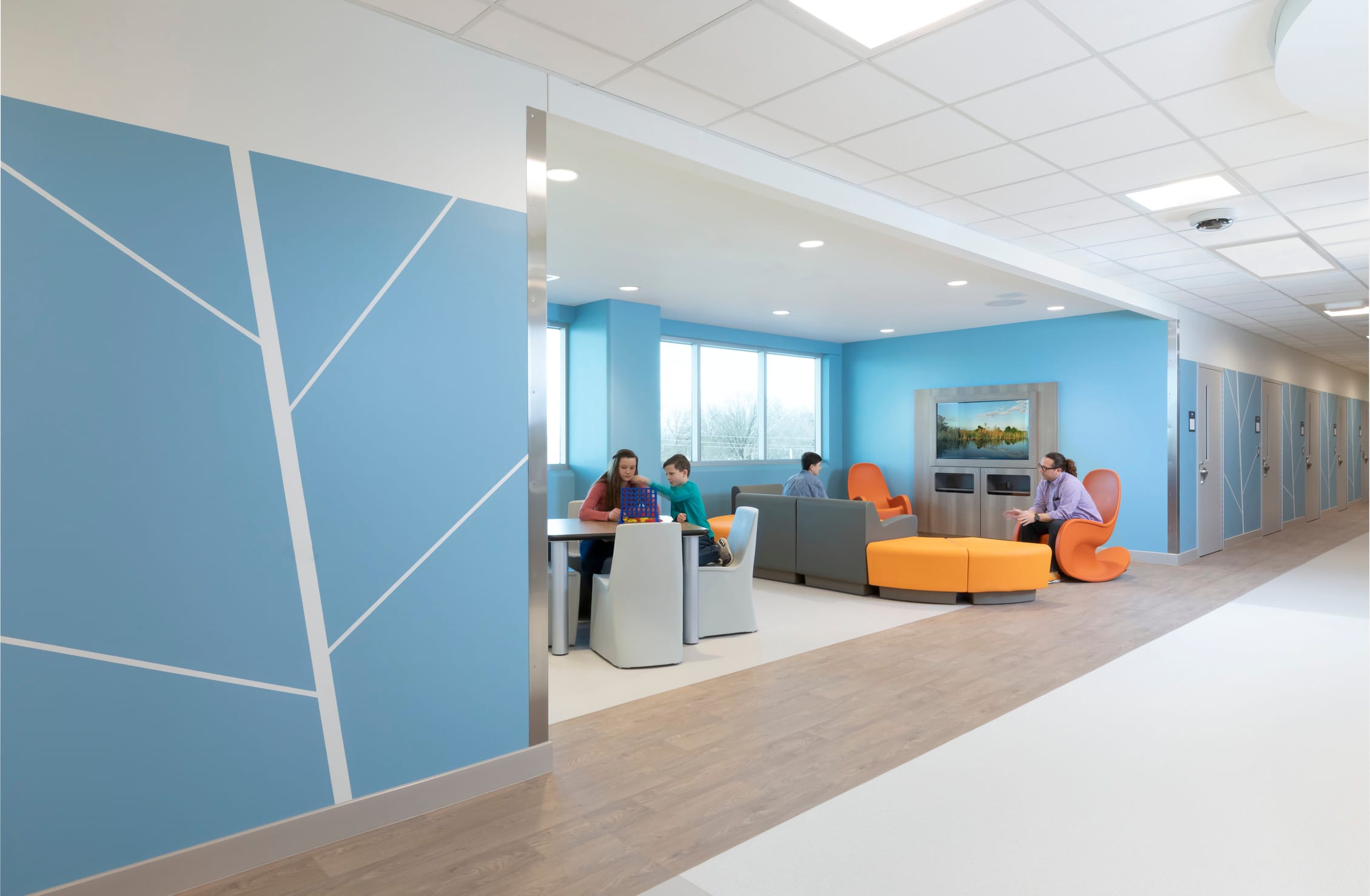 Interior of the NeuroDiagnostic Institute waiting room lobby. The walls and furniture are brightly colored shades of orange and blue. The interior is very light and not at all like the inside of a stereotypical psychiatric facility, highlighting BSA's expertise in environments that prioritize healing and patient well-being.