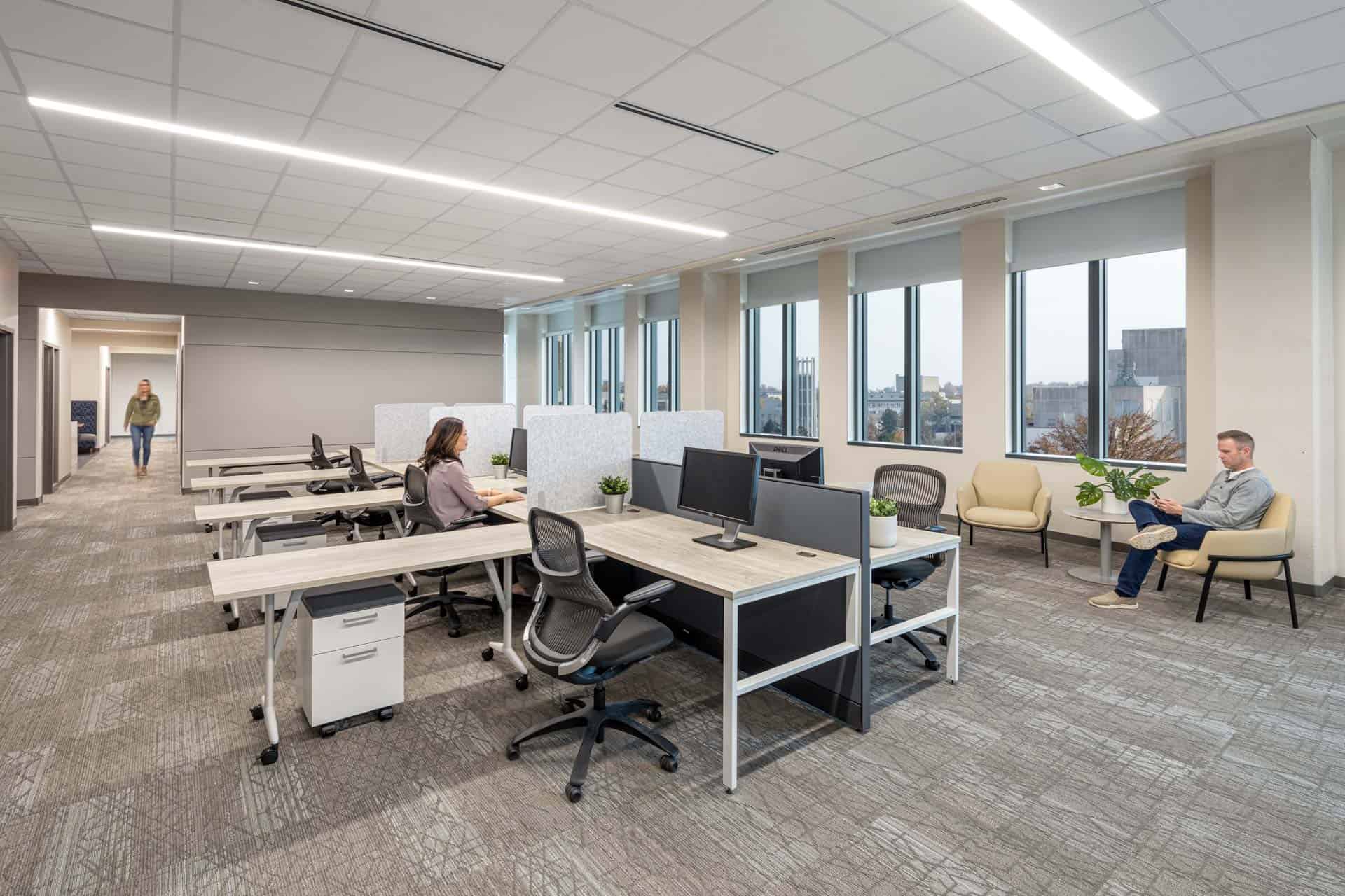 This image shows a modern workspace inside the Luddy Center for Artificial Intelligence. The room features eight workstations in a cubicle formation in the center of the room, each individual station having an 