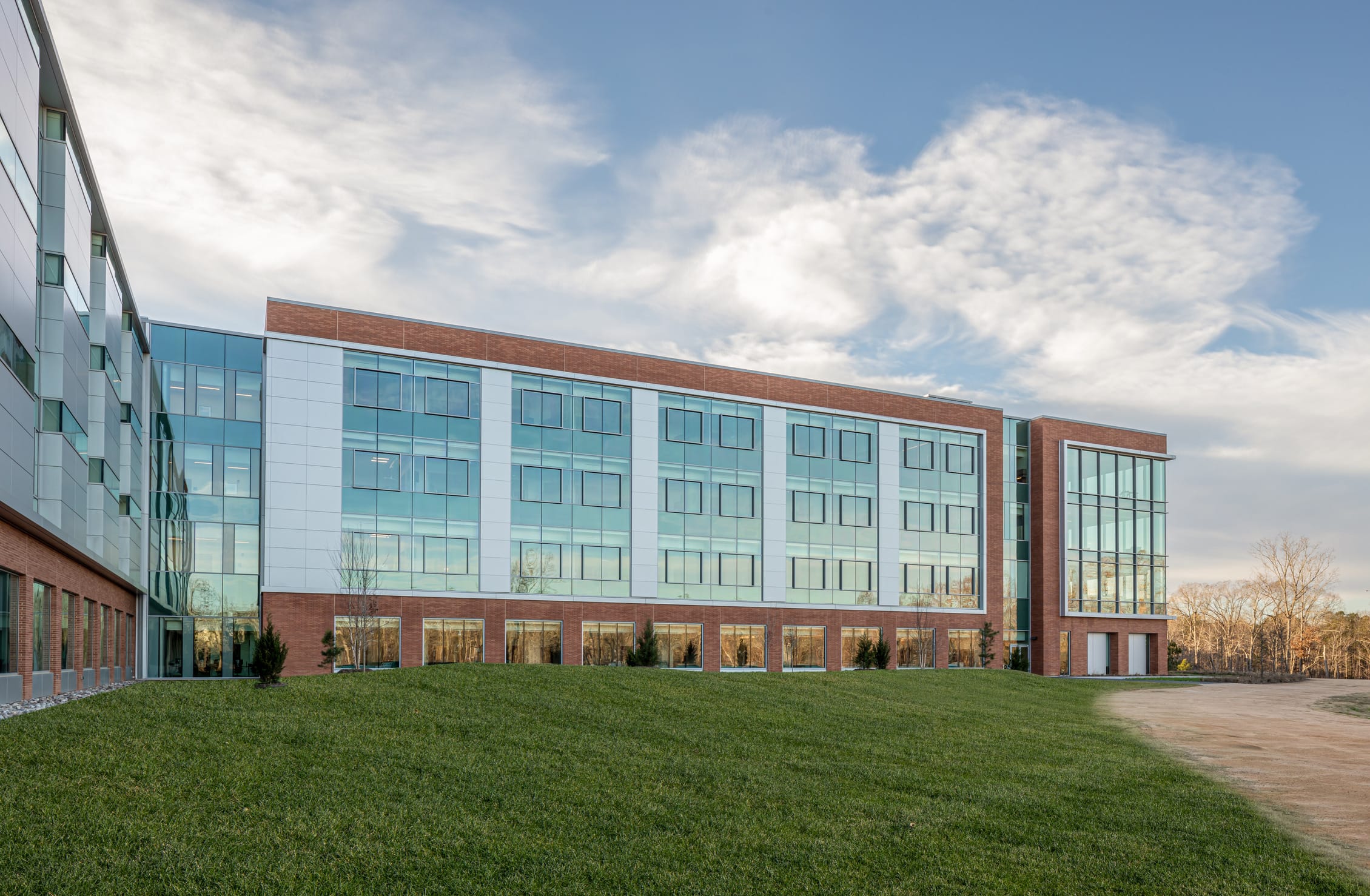 UNC Hospitals Hillsborough exterior featuring an all-glass design aside from brick pillars. This image showcases BSA's expertise in exterior architecture, namely all-glass structures.