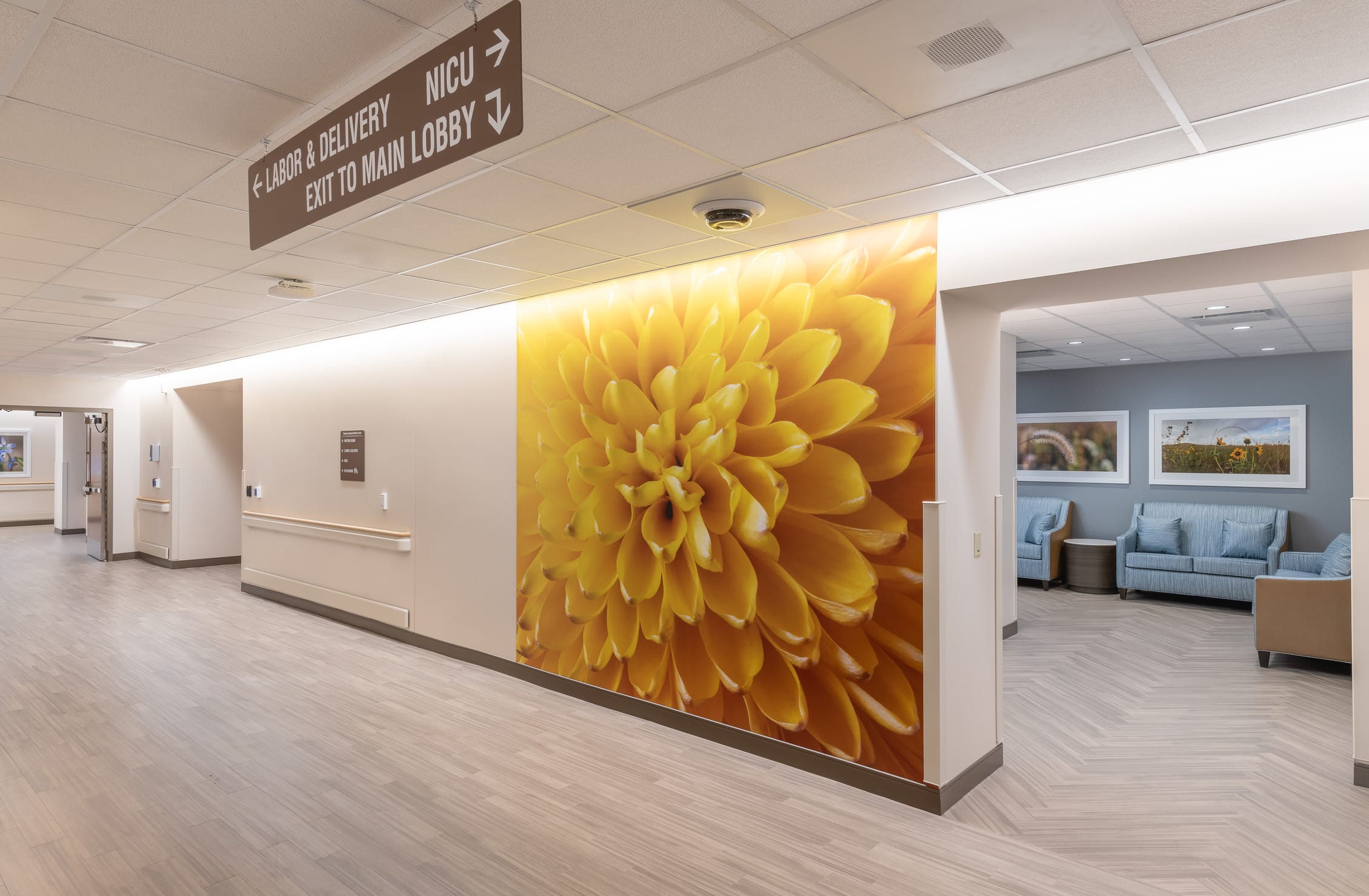 This image shows a hallway in the Cheyenne Regional Medical Center's labor and delivery unit. Prominent directional signage hangs from the ceiling indicating